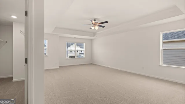 an empty room with windows and fan
