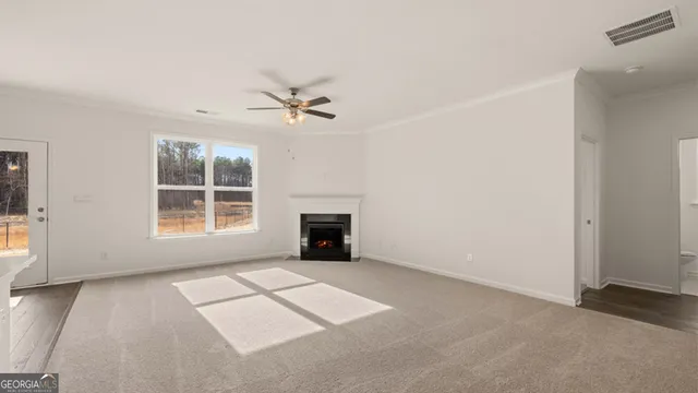 a view of an empty room with a fireplace and a window