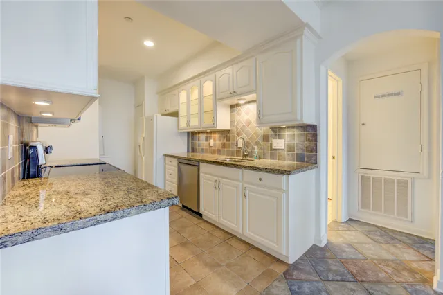 a kitchen with white cabinets and refrigerator