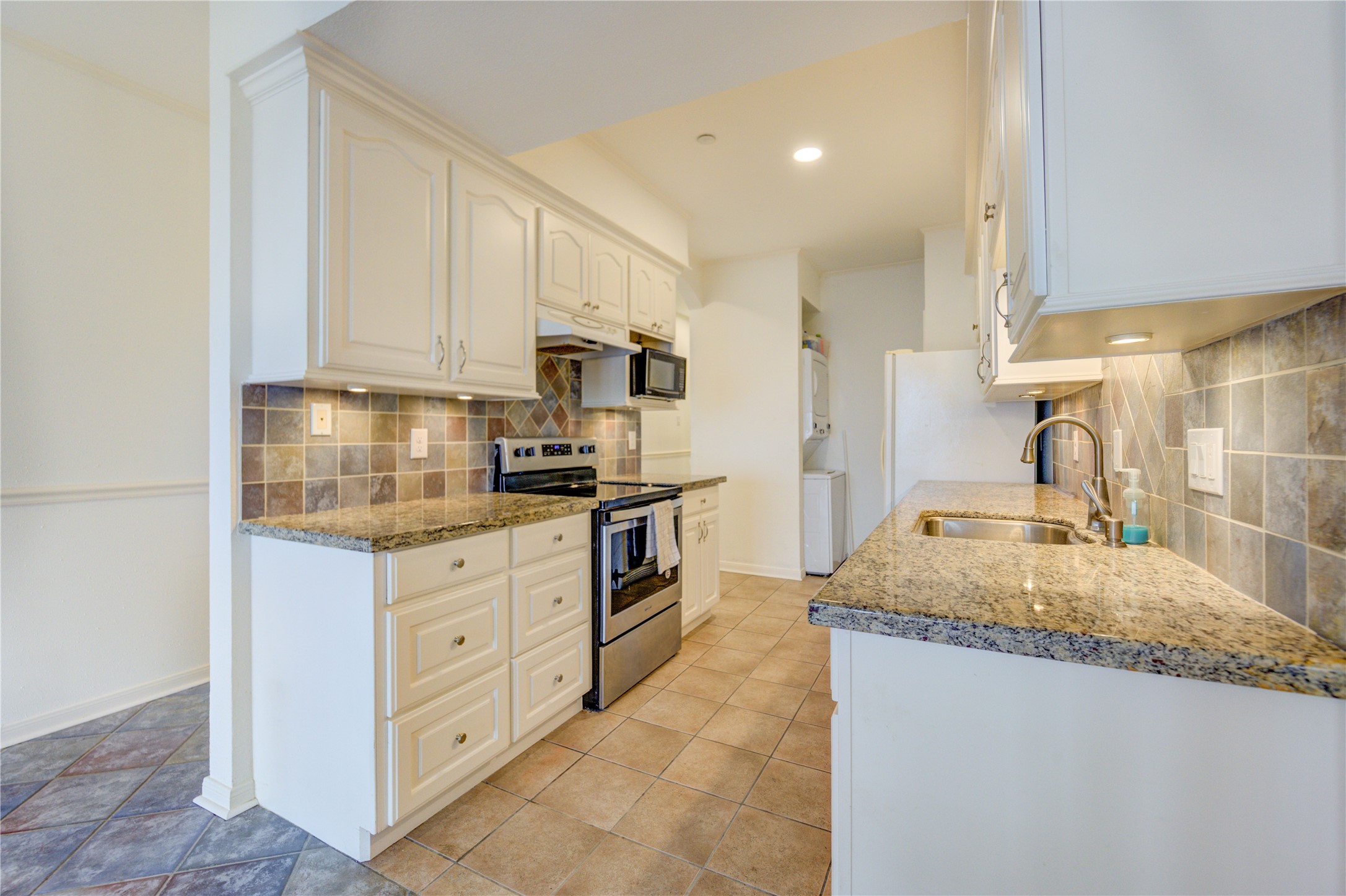 401 Lakeside Lane, Unit 106 Houston, TX 77058 - Photo 21 of 44 a kitchen with granite countertop a sink stove and cabinets
