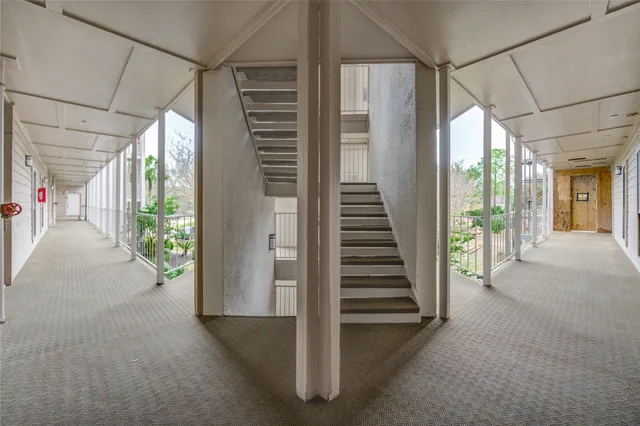 a view of road with card parked on side and retail shops