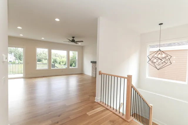 a view of a hallway with wooden floor and windows