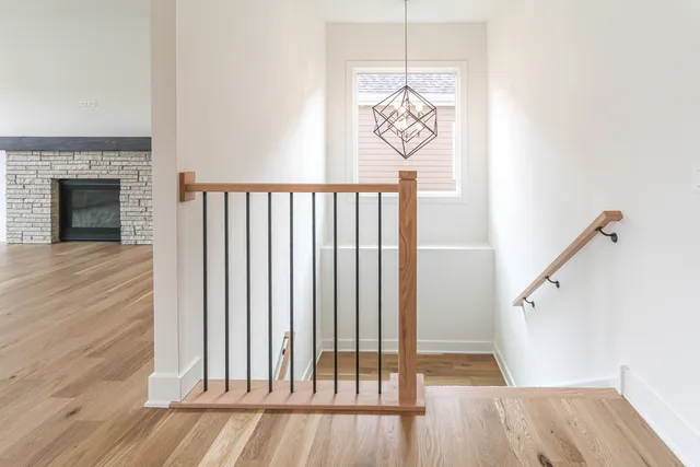 a view of a hallway with wooden floor and stairs