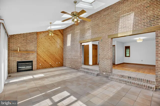 a view of an empty room with a fireplace and a window