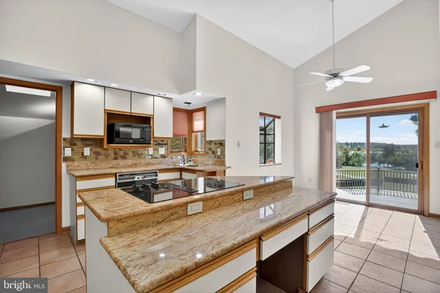 a kitchen with stainless steel appliances granite countertop a sink a stove top oven a counter space and cabinets