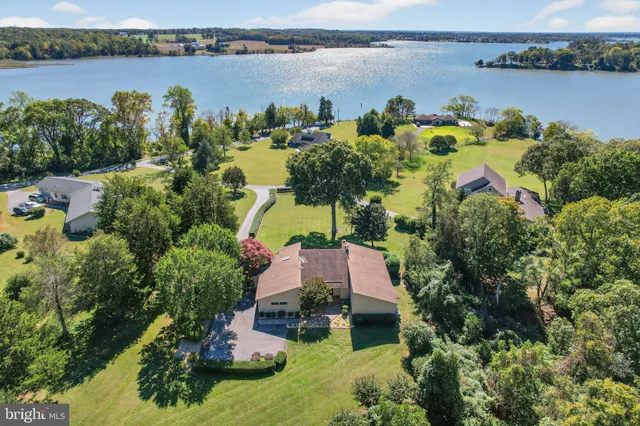 an aerial view of residential houses with outdoor space and lake view