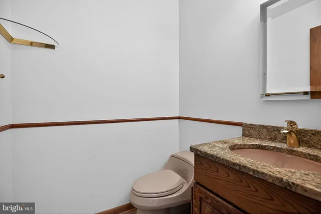 a bathroom with a granite countertop toilet and a sink