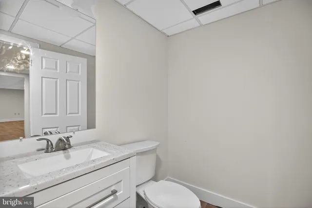 a bathroom with a granite countertop toilet sink and mirror