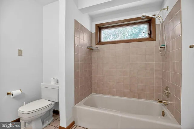 a white bath tub sitting next to a toilet