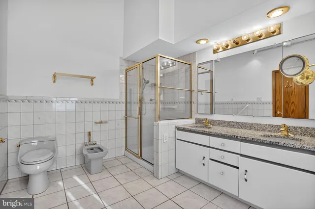 a spacious bathroom with a granite countertop sink a toilet and a mirror