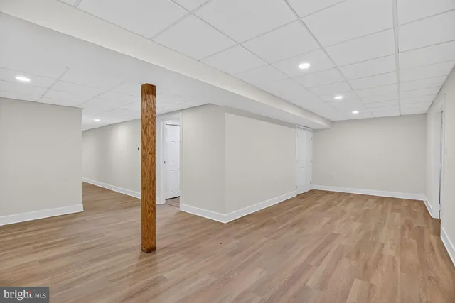 a view of empty room with wooden floor and windows
