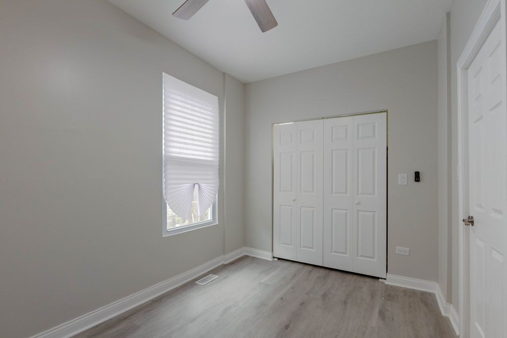 8538 South May Street Chicago, IL 60620 - Photo 12 of 38 an empty room with wooden floor and windows