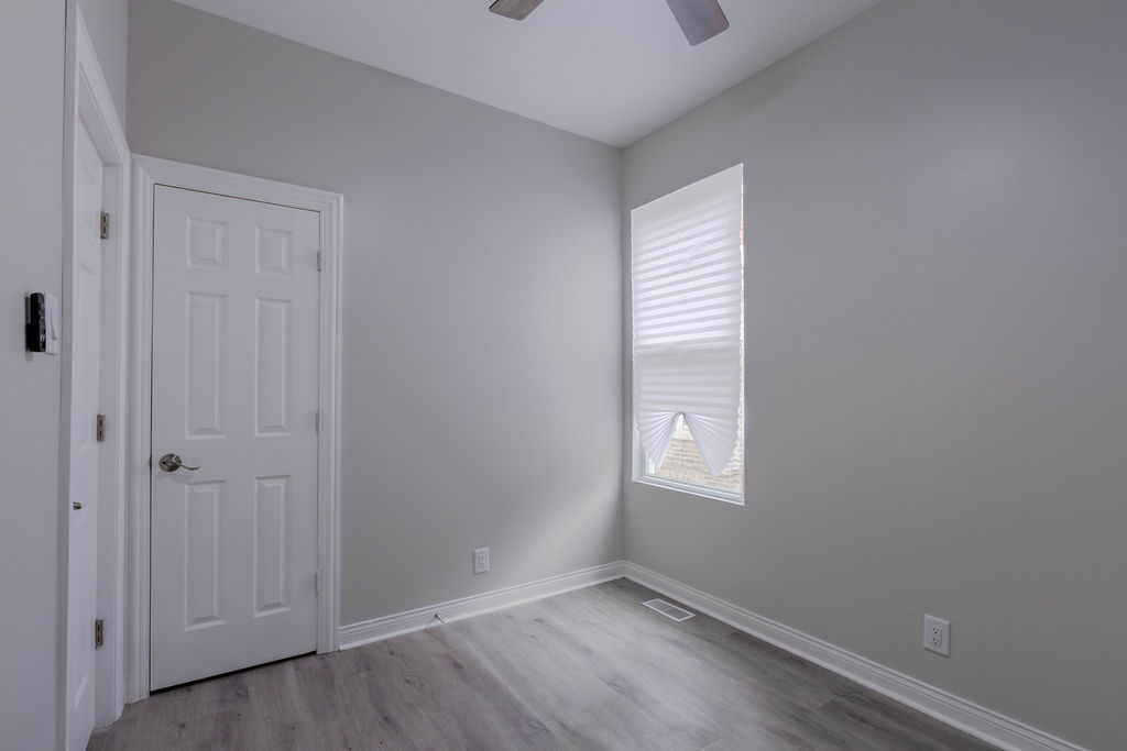 8538 South May Street Chicago, IL 60620 - Photo 18 of 38 a view of an empty room with wooden floor and a window