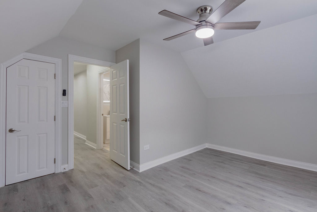 8538 South May Street Chicago, IL 60620 - Photo 21 of 38 an empty room with wooden floor and fan