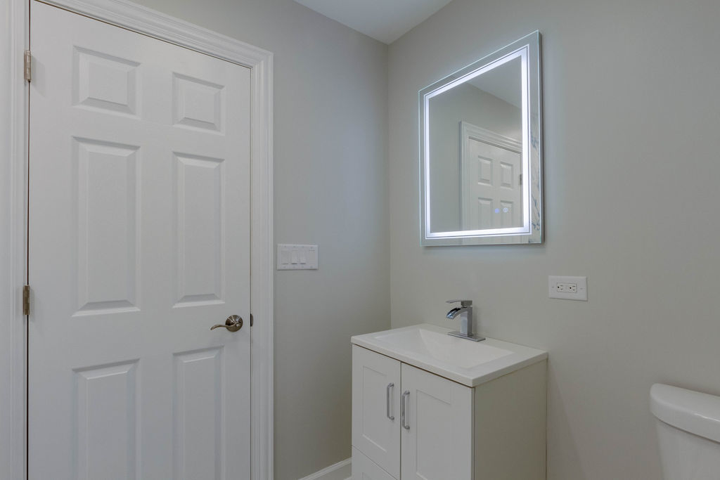 8538 South May Street Chicago, IL 60620 - Photo 23 of 38 a bathroom with a sink a toilet and vanity