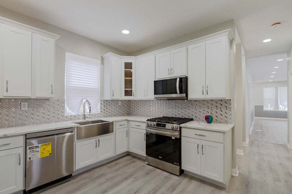 8538 South May Street Chicago, IL 60620 - Photo 9 of 38 a kitchen with stainless steel appliances granite countertop a stove a sink and a microwave