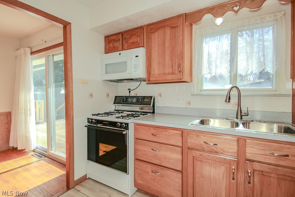30224 Regent Road Wickliffe, OH 44092 - Photo 8 of 27 Kitchen featuring range with gas stovetop, white microwave, light countertops, and plenty of natural light