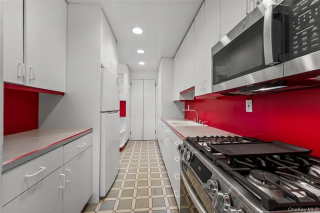 a kitchen with stainless steel appliances granite countertop a stove and a microwave