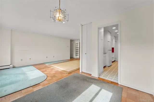 a view of a hallway with wooden floor and chandelier