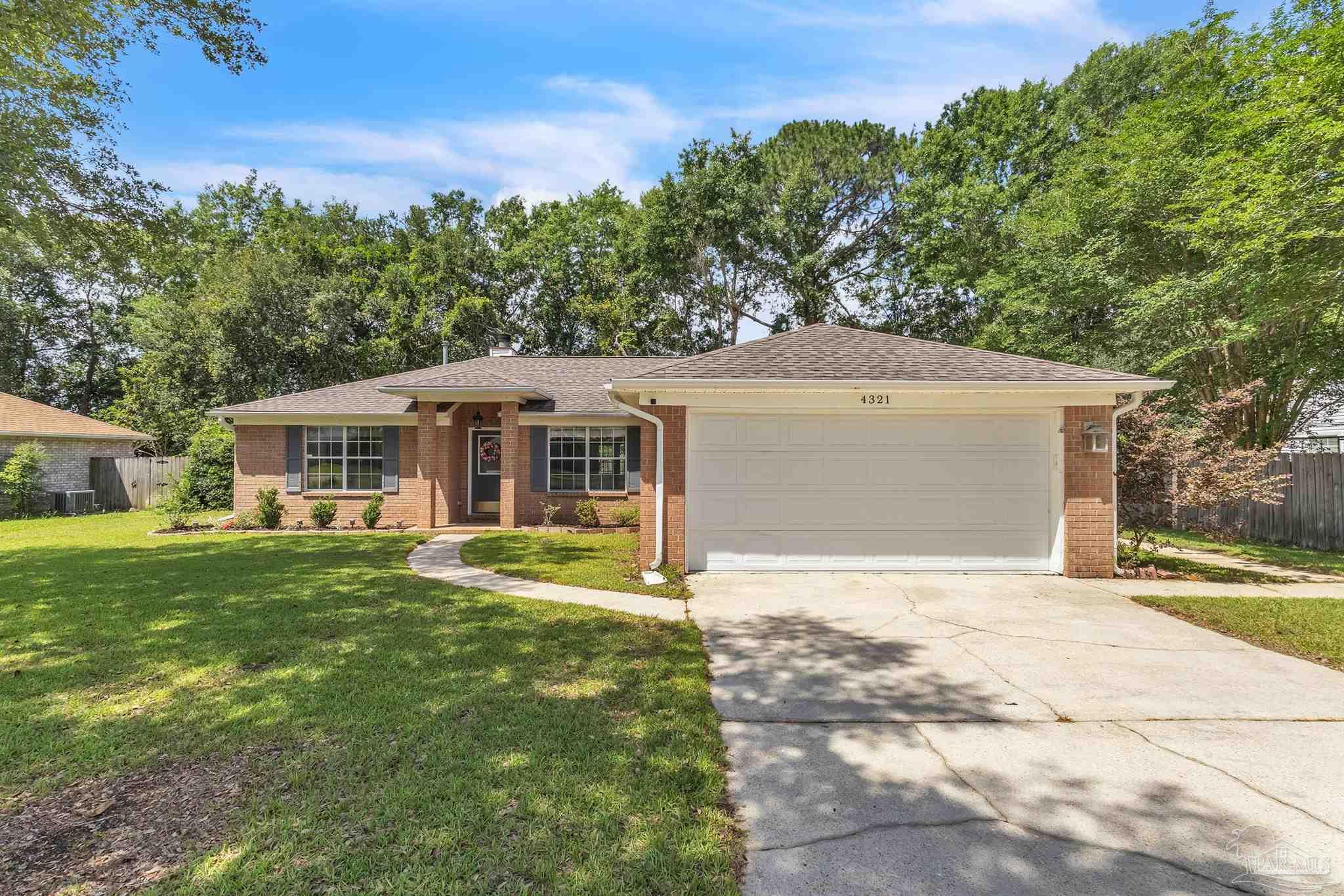 4321 Ridgeland Drive Pace, FL 32571 - Photo 28 of 36 a front view of a house with a garden and trees