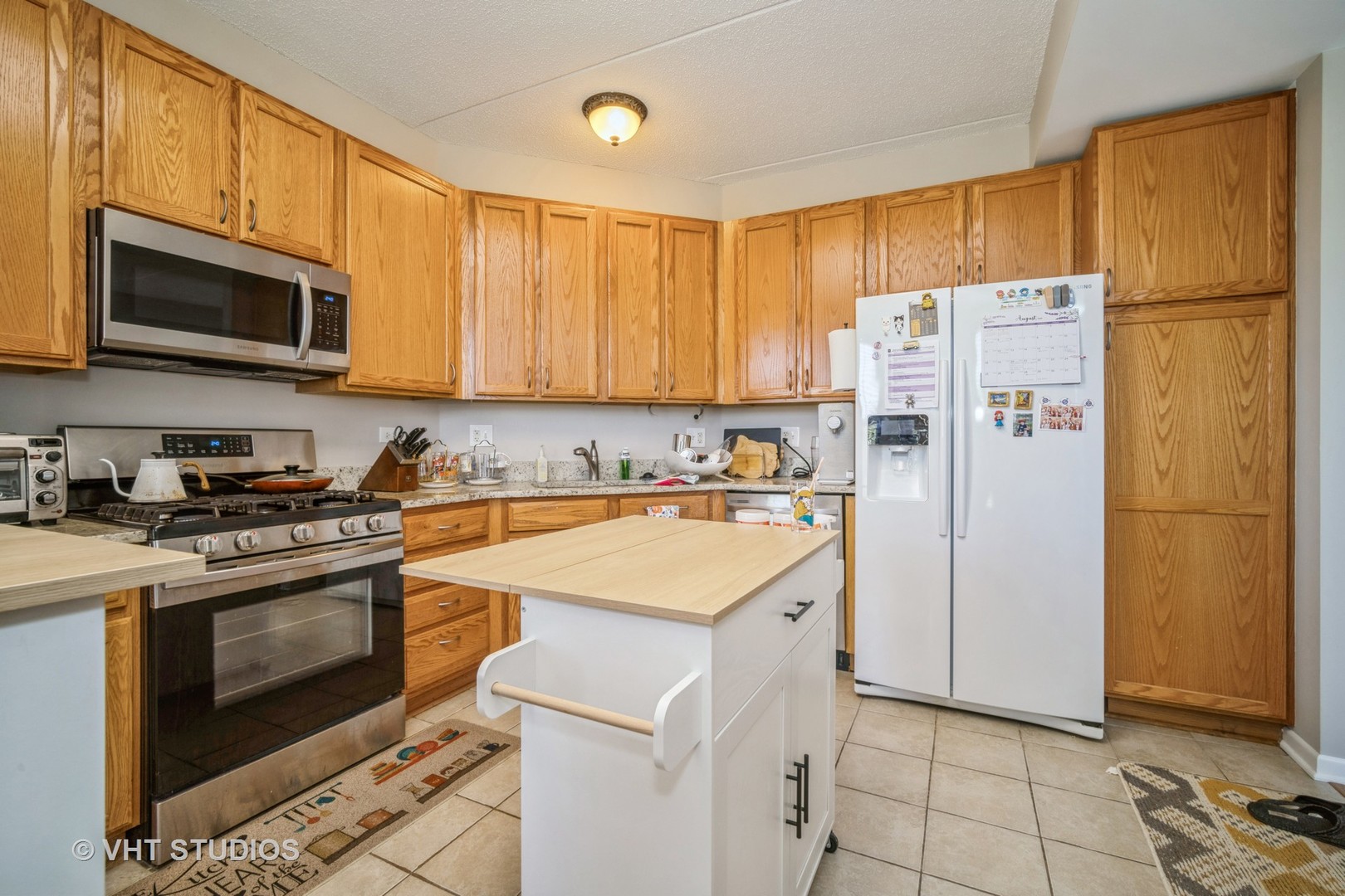 720 Prestwick Lane, Unit 307 Wheeling, IL 60090 - Photo 5 of 10 a white refrigerator freezer and a stove in a kitchen