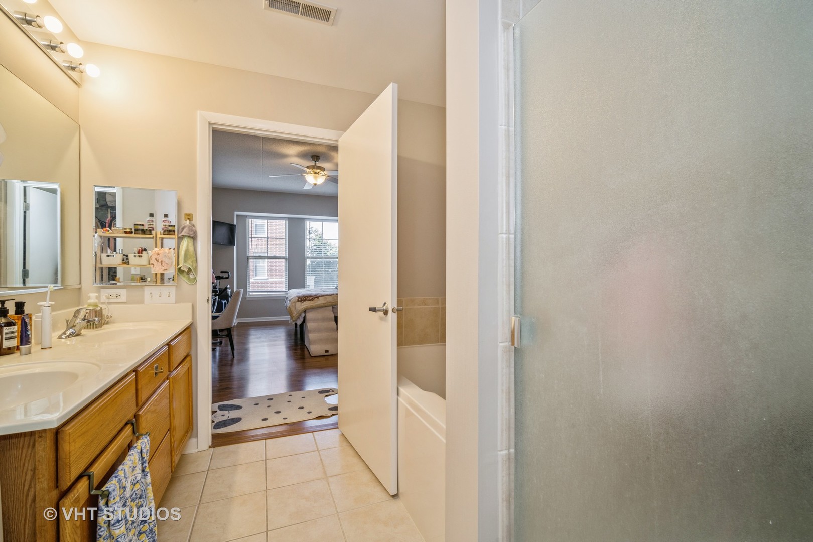 720 Prestwick Lane, Unit 307 Wheeling, IL 60090 - Photo 8 of 10 a bathroom with a sink a mirror and a shower
