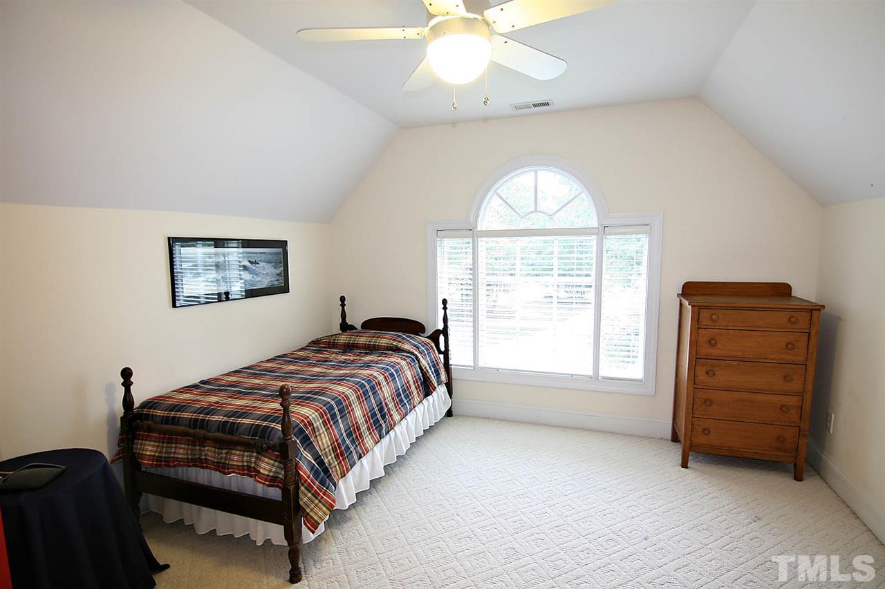10900 Fitzwilliam Street Raleigh, NC 27614 - Photo 17 of 25 a bedroom with a bed and a chandelier