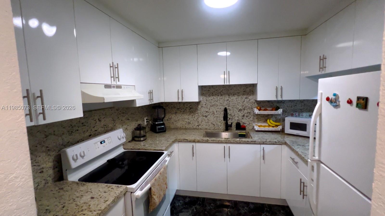 1900 West 68th Street, Unit D207 Hialeah, FL 33014 - Photo 1 of 33 a kitchen with a sink stove and refrigerator