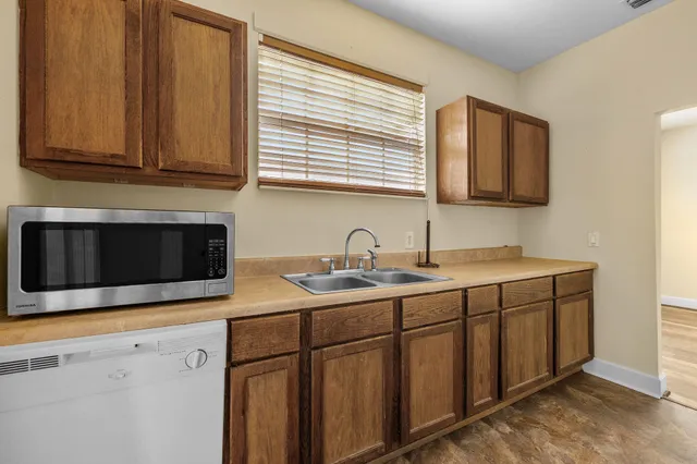 a kitchen with stainless steel appliances granite countertop a sink and a microwave