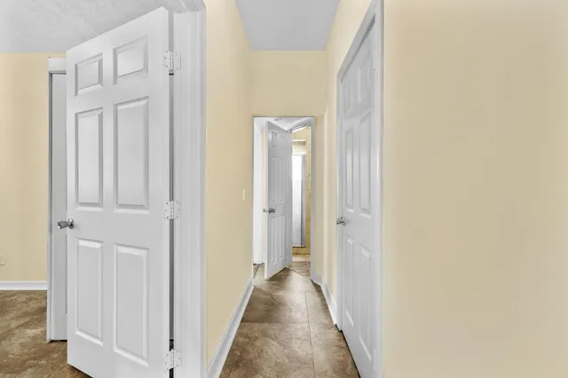 a view of a hallway with wooden floor and closet