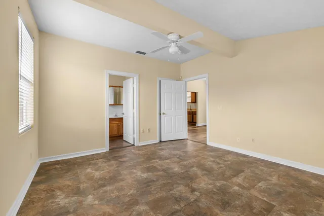 an empty room with an entryway and fan