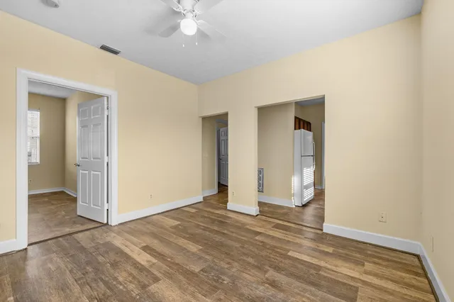 an empty room with a bathroom and a ceiling fan