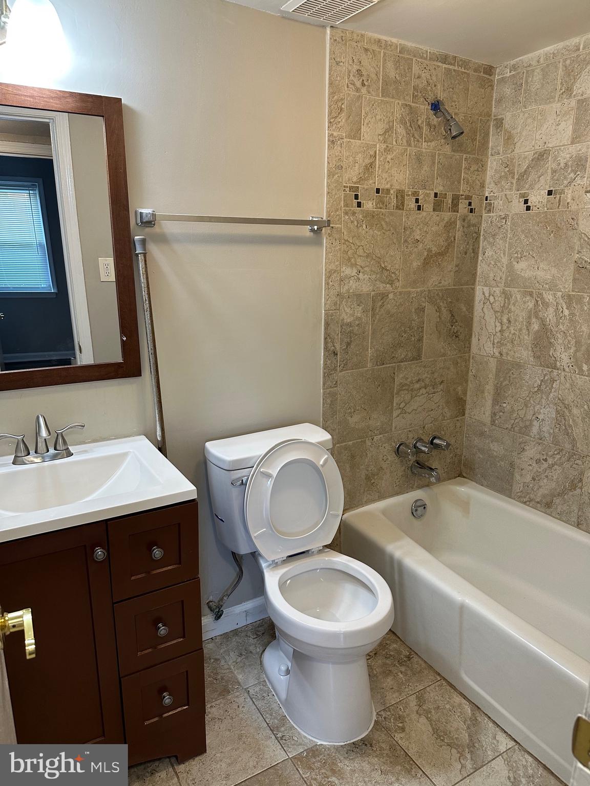 1805 Addison Road South District Heights, MD 20747 - Photo 13 of 28 a bathroom with a toilet a sink a mirror a bathtub and vanity