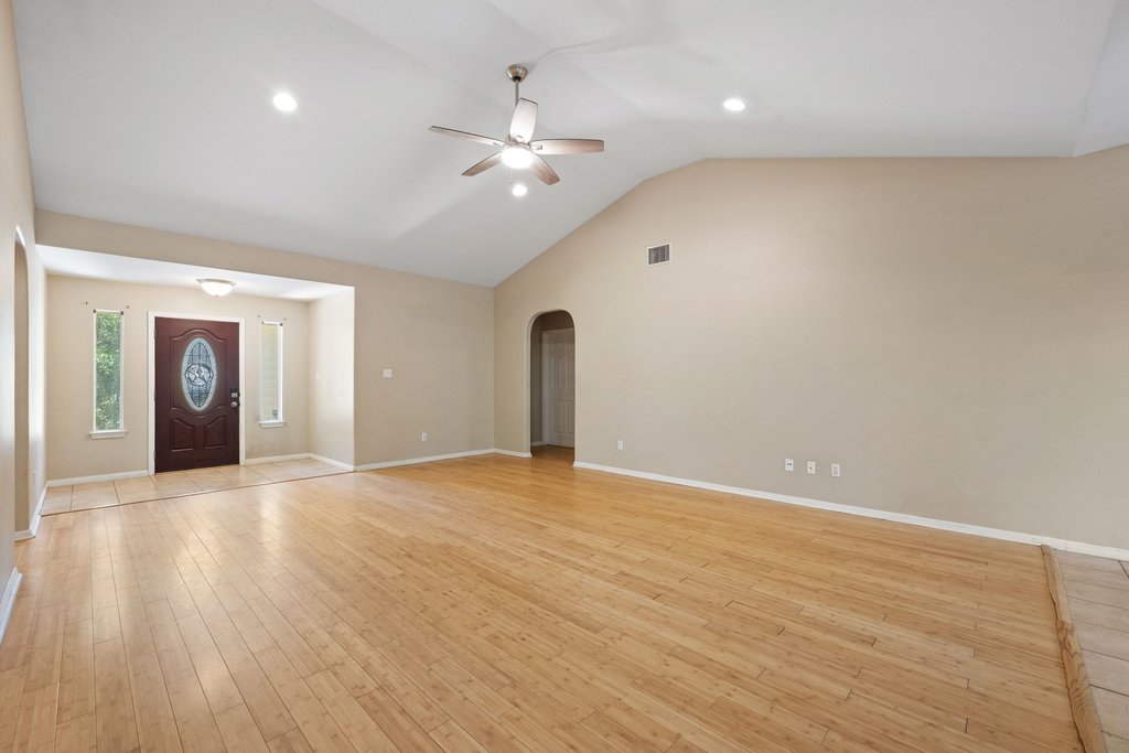 5208 Sioux Lane Austin, TX 78734 - Photo 14 of 35 Natural wood flooring complements the vaulted ceiling and recessed lighting in this inviting living space.