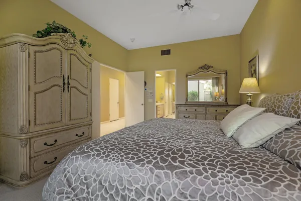 a bedroom with a bed and a mirror on dresser