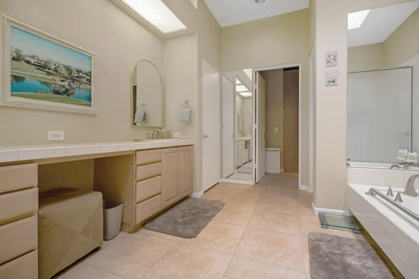 a spacious bathroom with a double vanity sink a mirror and a bathtub