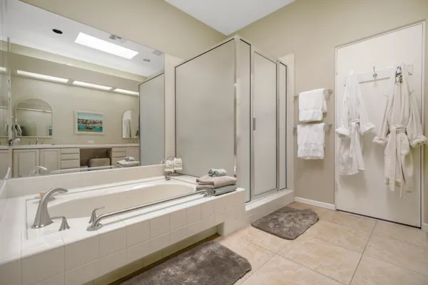 a spacious bathroom with a double vanity sink a mirror and a shower