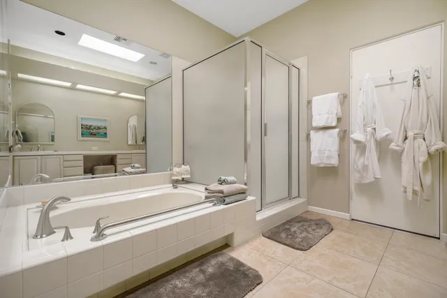 a spacious bathroom with a double vanity sink a mirror and a shower