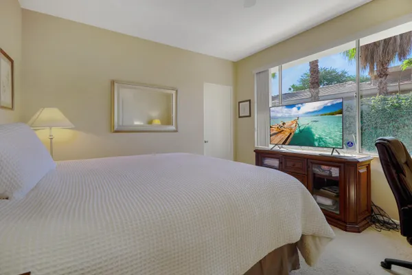 a bedroom with a bed a window and walk in closet