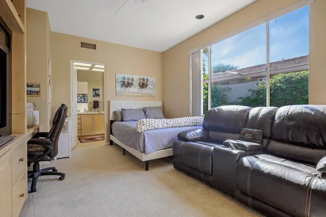 a bedroom with a bed couch and a window