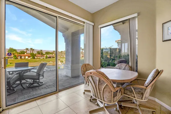 a dining room with furniture and a floor to ceiling window