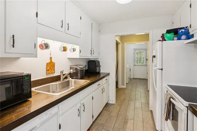 a kitchen with granite countertop a sink stove and refrigerator