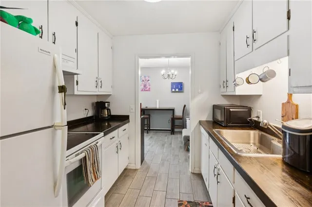 a kitchen with granite countertop a sink a stove and refrigerator