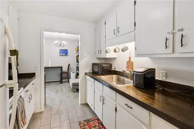 a kitchen with stainless steel appliances white cabinets sink and wooden floor