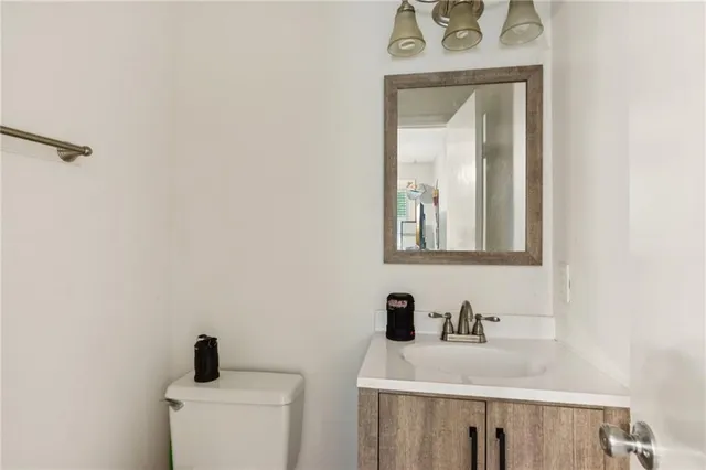 a bathroom with a toilet sink vanity and mirror