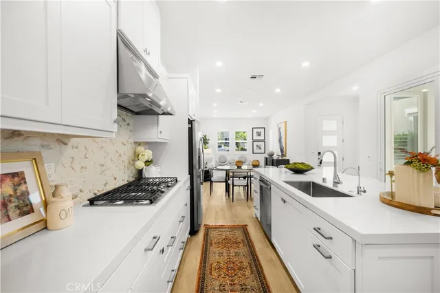 a kitchen with a sink a stove and cabinets