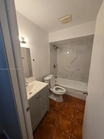 a bathroom with a sink a toilet a mirror and shower