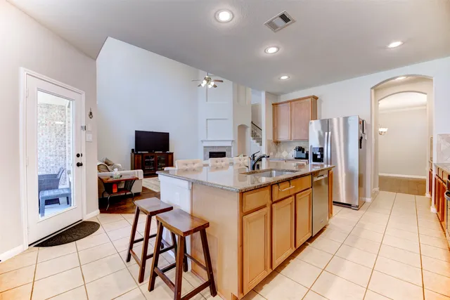 a large kitchen with kitchen island white cabinets and stainless steel appliances
