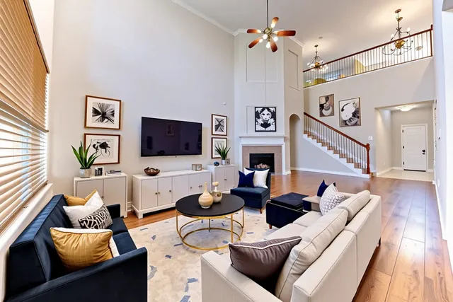 a living room with furniture a flat screen tv and a wall painting