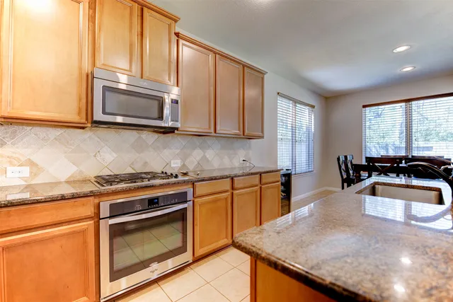 a kitchen with stainless steel appliances granite countertop a sink stove and microwave